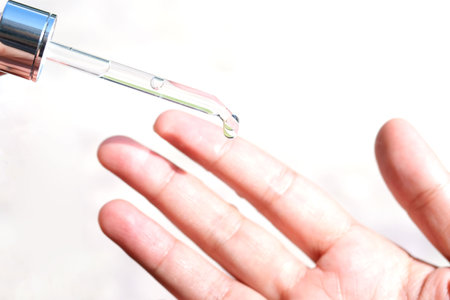 hands of a beautiful woman Dropping serum collagen moisturizer of face into hand soft light background. Protector skin Treatment facial essence oil, Vitamin C. Beauty and spa conceptの写真素材