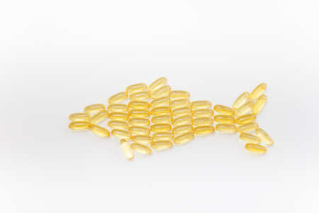 Fish shape Cod Liver Oil Capsules, Omega 3, Vitamin D on white background.