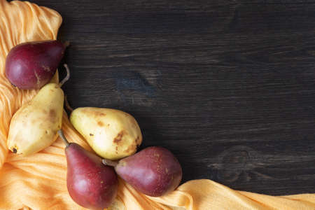 Ripe organic red and yellow pears on a dark wooden background. Fresh pear closeup. Background with...