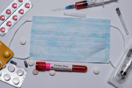 Blood positive test to coronavirus. Medical reseach, test-tube with blood, medical mask, syringe,...