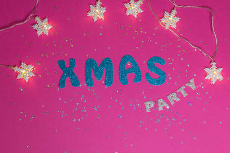 Words Xmas Party on pink background with glittered little stars and stars garland. Christmas inscription with space for text writing, greeting. Concept for Christmas card. Top view. High quality photoの写真素材