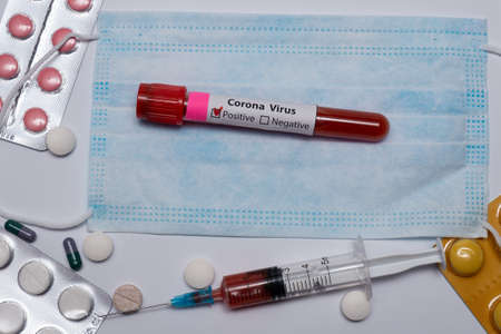 Blood positive test to coronavirus. Medical reseach, test-tube with blood, medical mask, syringe,...