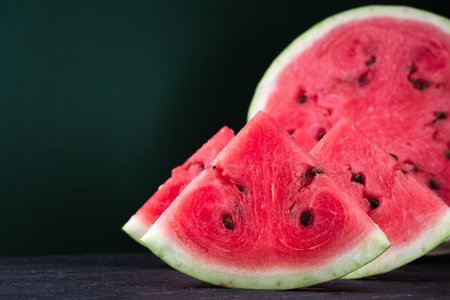 Pieces of refreshing watermelon on a dark wood background. Close-up photo. Fruit textureの写真素材
