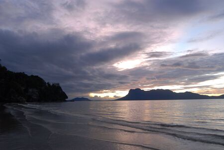 Sun setting off the island of Borneoの写真素材