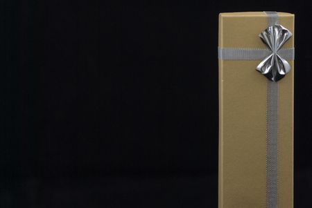 Christmas gift with silver bow on black backgroundの写真素材