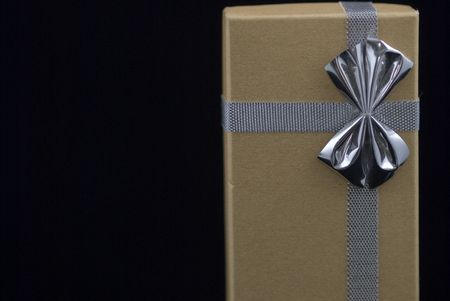 Christmas gift with silver bow on black background