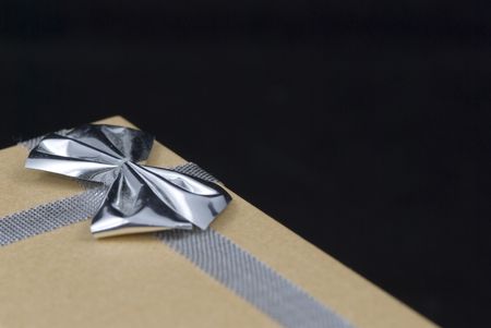 Christmas gift with silver bow on black backgroundの写真素材