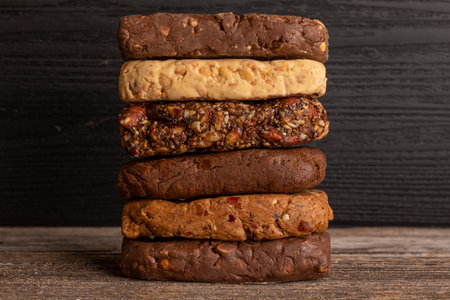 Different types of cereal bars on a wooden background. Healthy food concept.の写真素材