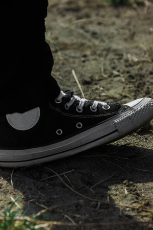 black sneakers on the ground in the park, closeup of photoの写真素材