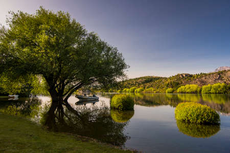 Quiet landscape with a boat and no wind in FutaleufÃº River, Chubut Province, Argentina.
