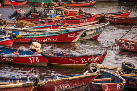Red fisherÂ´s empty boats anchored in AntofagastaÂ´s harbor with different names and numbers and...