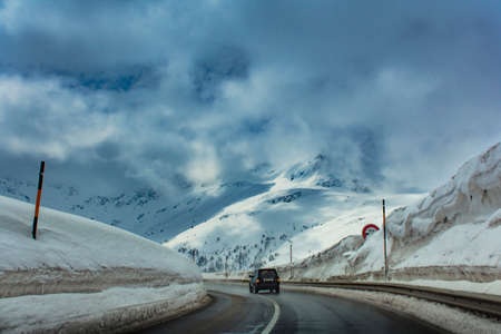 Road with one car and a lot of snow in the Alps. Switzerland, Europeの写真素材