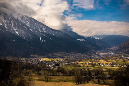 Green valley with some houses between the snowed mountains in center Switzerland, Europe