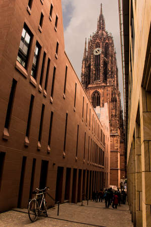Bycicle in a narrow street with the city icon Collegiate Church of Frankfurt on the Main at the Background. Frankfurt, Germanyのeditorial素材