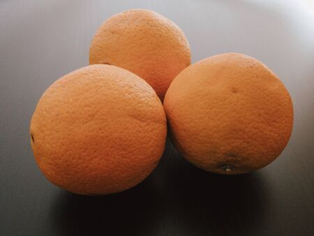 Three Oranges In Black Backgroundの写真素材