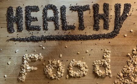 Healthy Food written with chia and oats on a wooden board. Vegetable banner.の写真素材