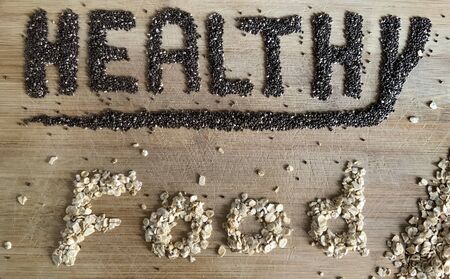 Healthy Food written with chia and oats on a wooden board. Vegetable banner.の写真素材