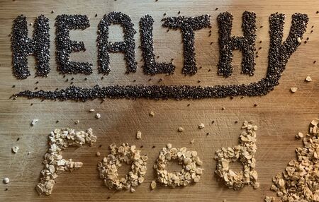Healthy Food written with chia and oats on a wooden board. Vegetable banner.の写真素材