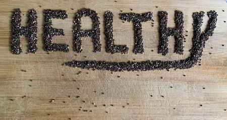 Healthy Food written with chia and oats on a wooden board. Vegetable banner.の写真素材