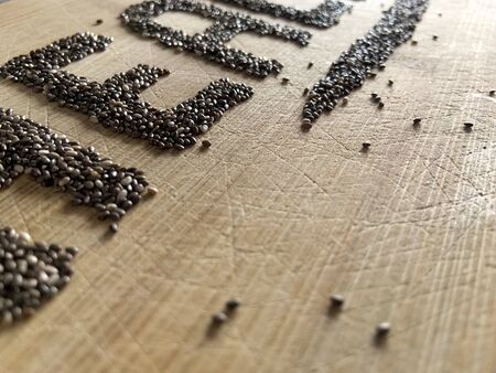 Healthy Food written with chia and oats on a wooden board. Vegetable banner.の写真素材
