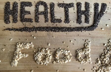 Healthy Food written with chia and oats on a wooden board. Vegetable banner.の写真素材