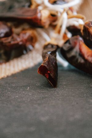 Hot chilli pepper on black background with rustic cloth, vintage tablecloth. Spicy traditional with...