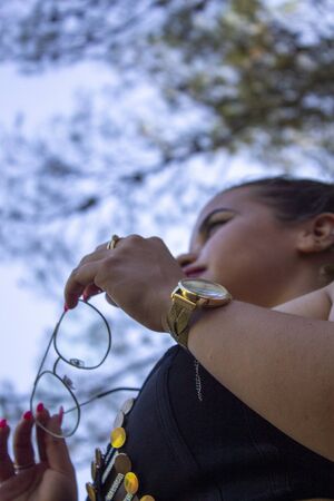 woman removes glasses and holds them in her hand, wearing contact lenses taking off her annoying glasses. Proud of the lenses.の写真素材