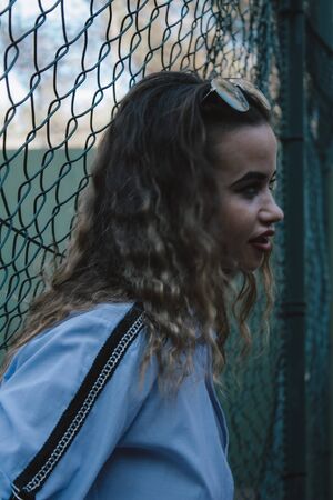 Portrait woman with curly hair on a metal rack. Thick lips painted with glasses.の写真素材