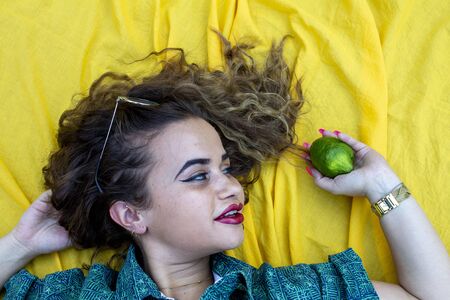 Vertical side profile top above high angle photo beautiful she her lady lying down show perfect shiny ideal hair above head slim skinny wearing formal wear yellow cloth background backgroundの写真素材