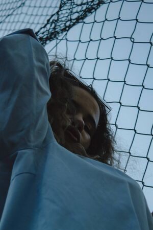 Portrait woman with curly hair on a metal rack. Thick lips painted with glasses.の写真素材