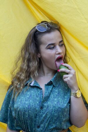 Young woman biting lemon. Acid and bitter.の写真素材