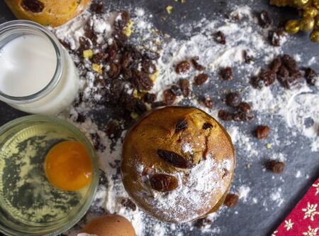 Christmas Panettone with slice and preparing ingredients to make panettone with egg, milk, and...
