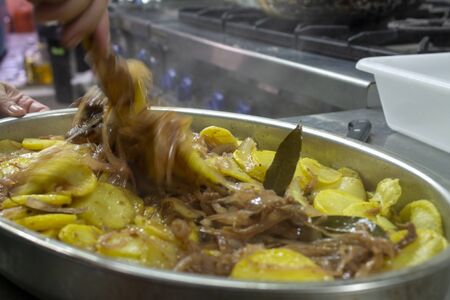 Cook preparing poor potatoes, typical of Spain with potatoes and onions. Typical dish in preparation.の写真素材