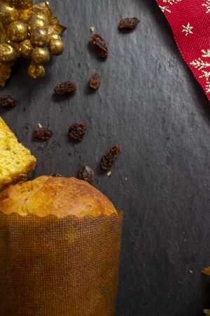 Christmas Panettone with slice and preparing ingredients to make panettone with egg, milk, and raisins setting. Typical Italian Christmas holiday cakeの写真素材