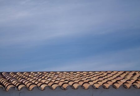 Roof with blue sky with classic terracotta tiles. With clouds in the sky.の写真素材