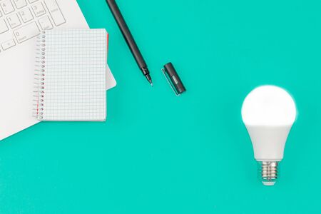 Light Bulb, Laptop and Notepad on Blue Backgroundの写真素材