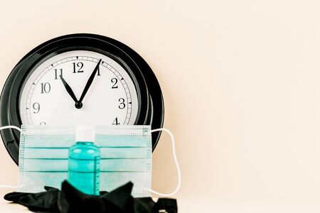 medical mask with watch, sanitizing ge and black medical gloves, time concept for vaccine and covidの写真素材