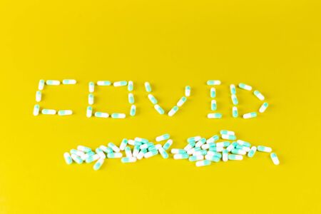word covid written with blue pills on a blue background, concept of covid and writing with pills