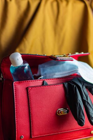 A Red woman's bag in the new normality, concept of going out with mask and gloves to the street....