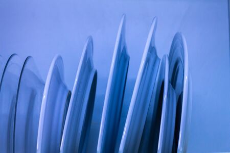blue dish drainer con platos uno detras de otro, housework conceptの写真素材