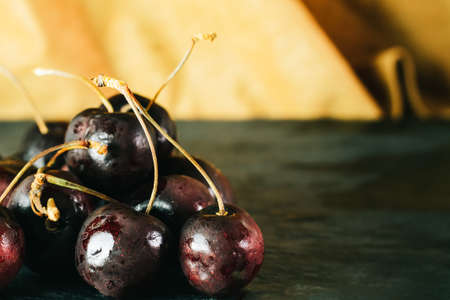 Fresh Cherries on black slate with autumn background.の写真素材