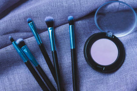 Eye make-up brushes and pink eyeshadow. Concept of beauty and make-up tutorial.