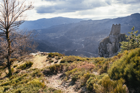 Path leading towards medieval tower ruins built on a rockの写真素材