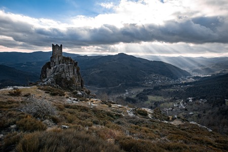 Tower ruins and a valley enlightened by lightbeamsの写真素材