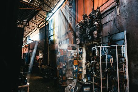 Shops in the Medina Market, Marrakech, Morocco with rays of sunlight penetrating between the buildings and an array of goods displayed for saleの写真素材