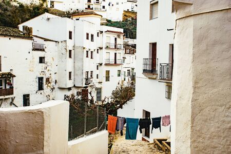 View down a narrow street with washing clothesの写真素材