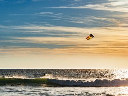 Kite surfer surfing at sunset at Tarifa beachの写真素材
