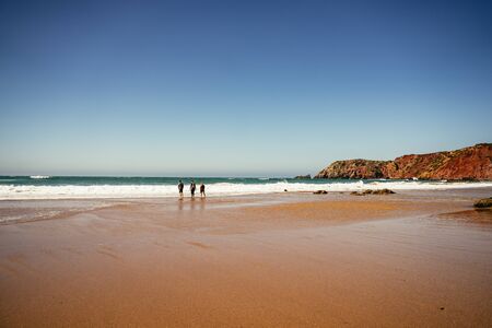 Surfers entering the ocean at Praia do Amadoの写真素材