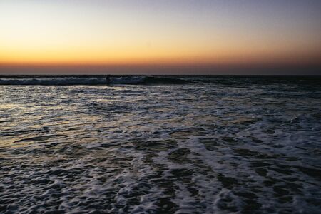 Surfer in the sea at sunset Sidi Kaouki, Moroccoの写真素材