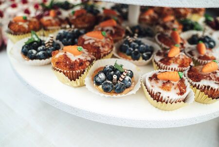 Delicious miniature cakes in buffet trays. Fruit decorated cupcakes. Various desserts at party. Celebration, party, birthday or wedding concept.の写真素材
